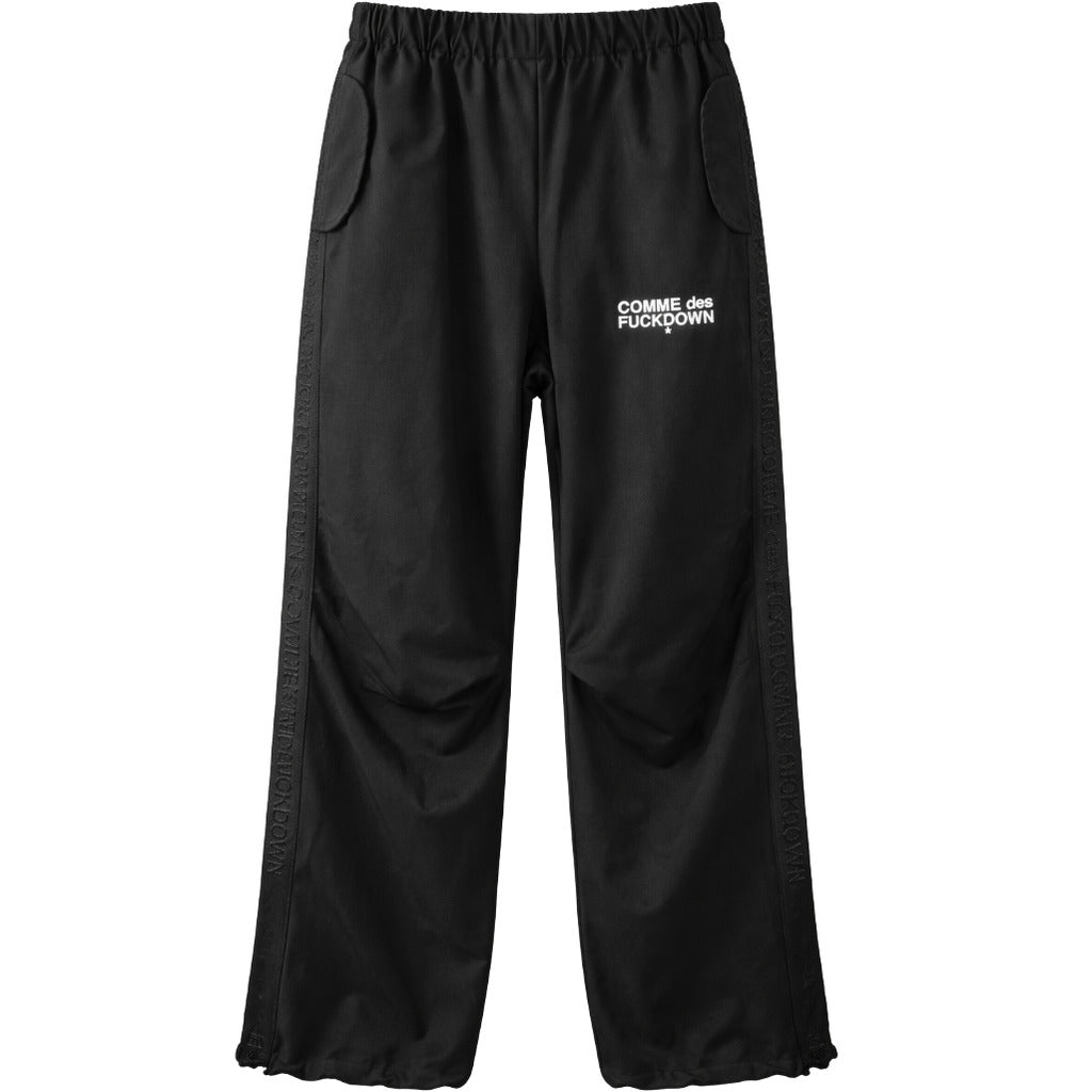 Comme Des Fuckdown – black wide-leg logo trousers – flat front view with elastic waist and side stripes