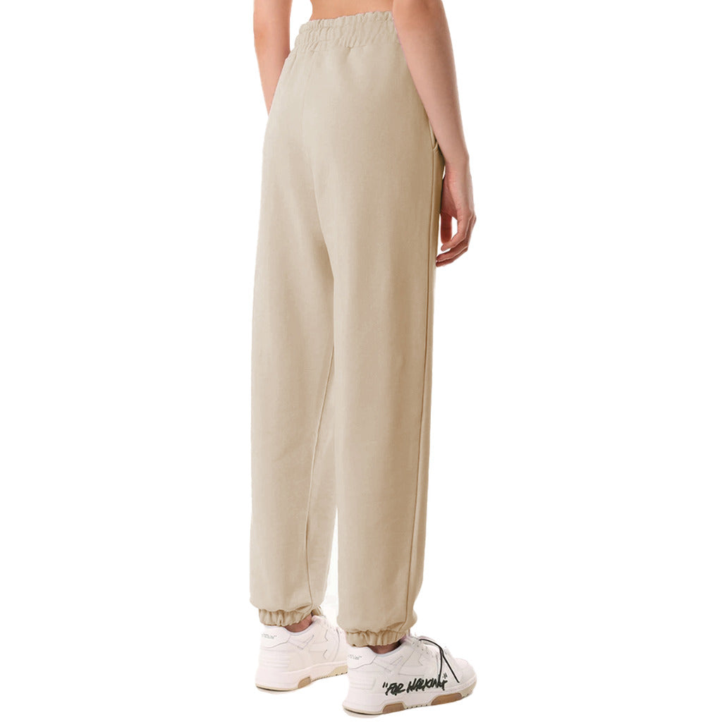 Comme Des Fuckdown – beige sweatpants – rear three-quarter view worn with white sneakers