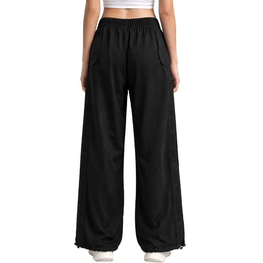 Comme Des Fuckdown – black wide-leg logo trousers – model wearing them from the back