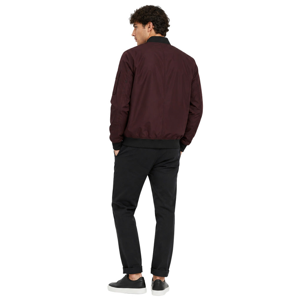 Moose Knuckles – burgundy jacket with black trim – model wearing jacket, rear three-quarter view
