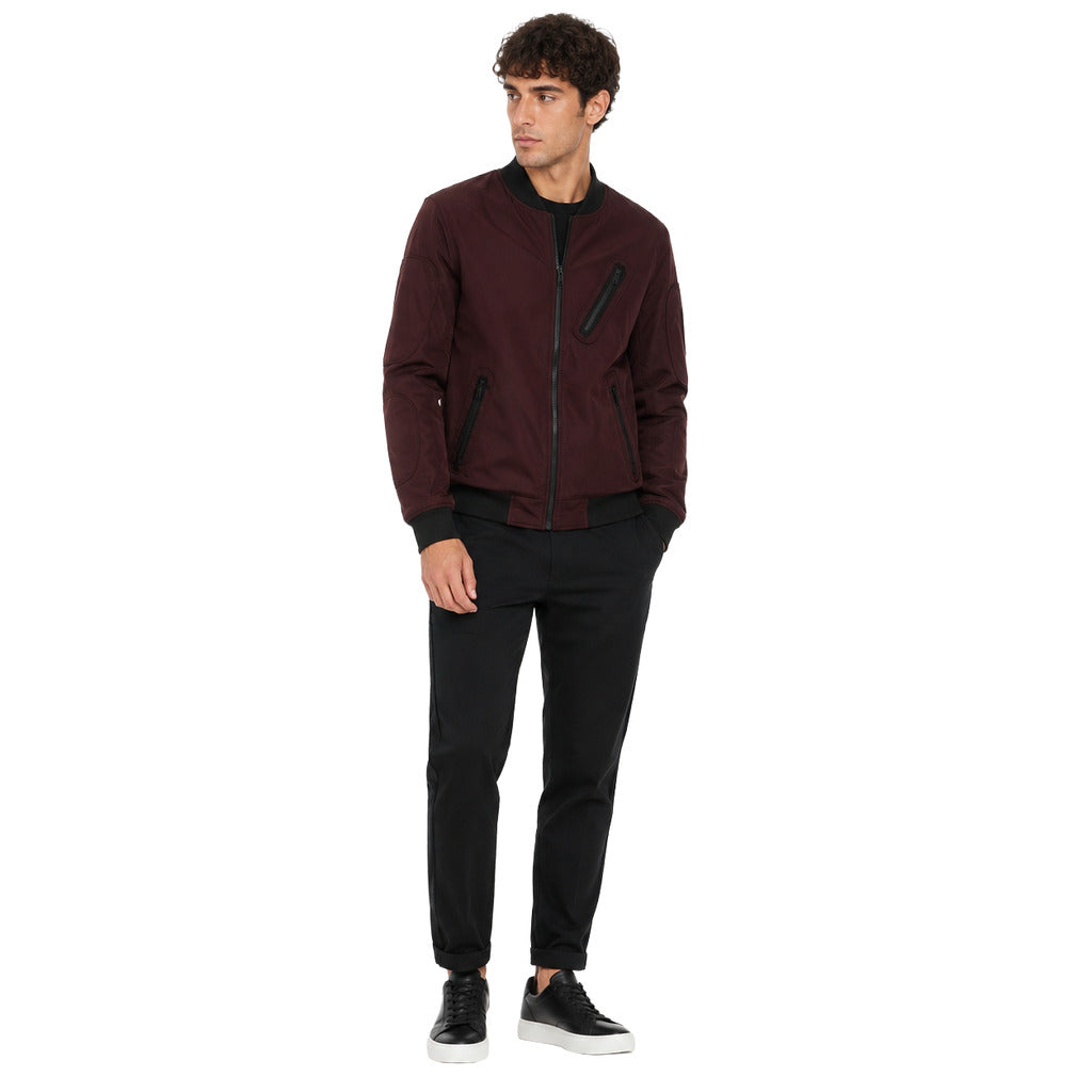 Moose Knuckles – burgundy jacket with black trim – model wearing front view with black trousers
