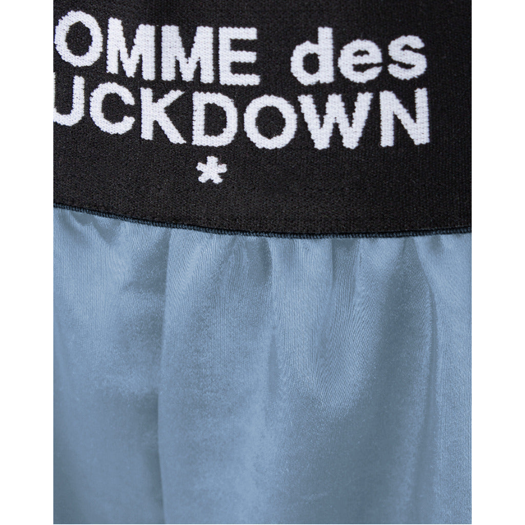 Comme Des Fuckdown – light blue shorts with black waistband – close-up of logo and fabric