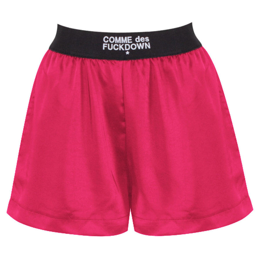Comme Des Fuckdown – Satin Shorts in Fuchsia – flat front view with black logo waistband